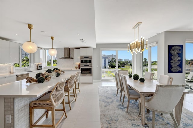 dining area featuring a notable chandelier, a view of city, light tile patterned flooring, and visible vents