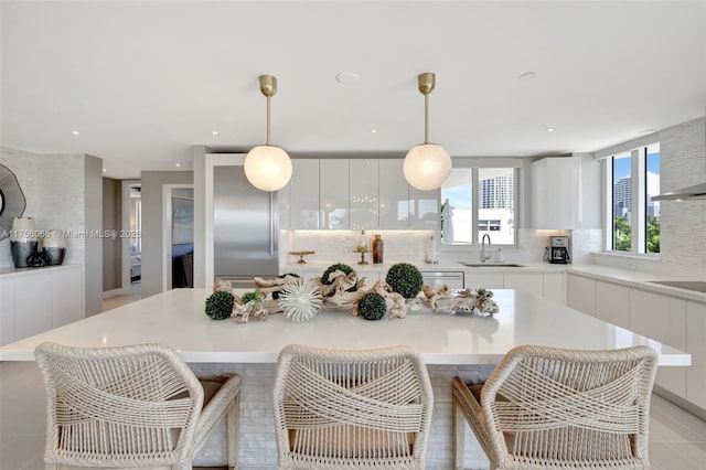 kitchen with white cabinets, a breakfast bar, modern cabinets, and a sink