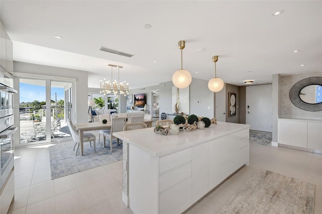 kitchen featuring visible vents, pendant lighting, white cabinetry, modern cabinets, and a center island