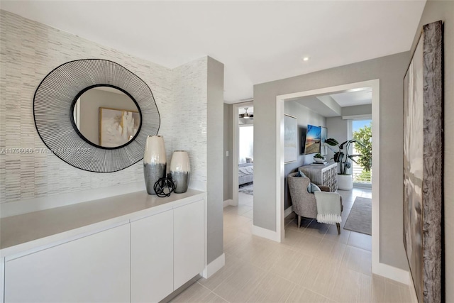 hallway with light tile patterned floors and baseboards