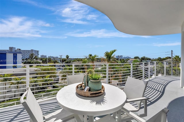 balcony with a view of city and outdoor dining area