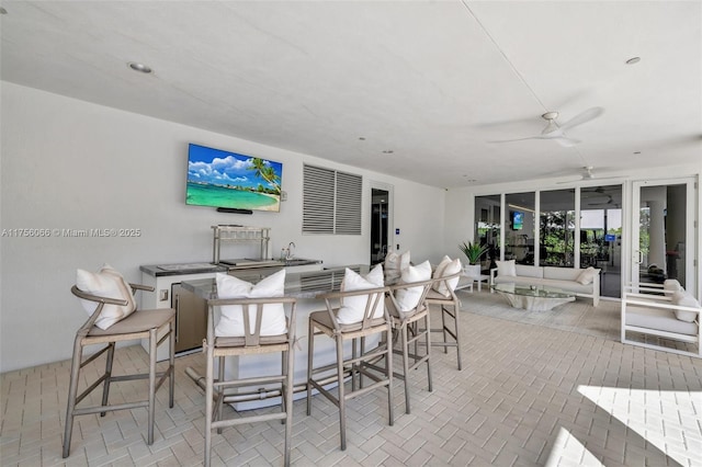 view of patio / terrace with an outdoor living space, outdoor wet bar, and ceiling fan