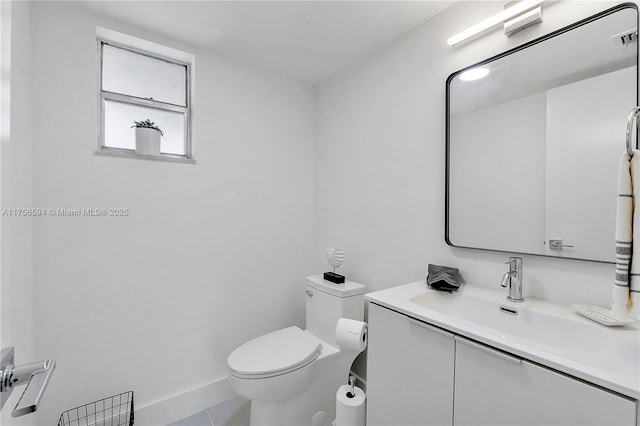 half bathroom featuring baseboards, visible vents, toilet, tile patterned flooring, and vanity