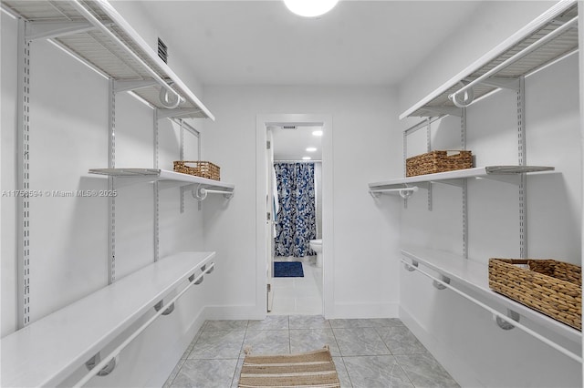 spacious closet with light tile patterned floors and visible vents