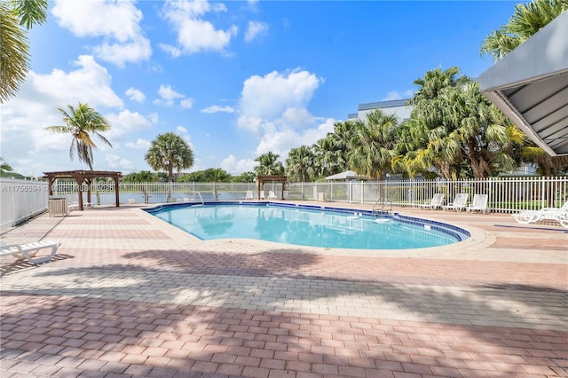 pool with a patio area and fence