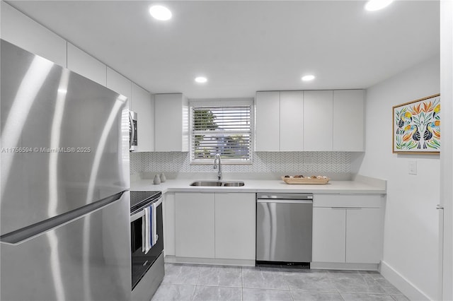 kitchen with light countertops, appliances with stainless steel finishes, a sink, and white cabinets