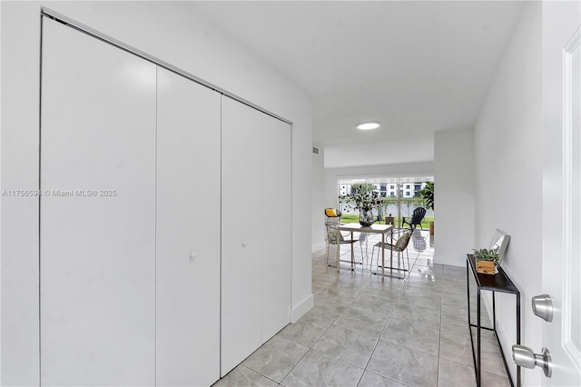 hall featuring visible vents and light tile patterned floors