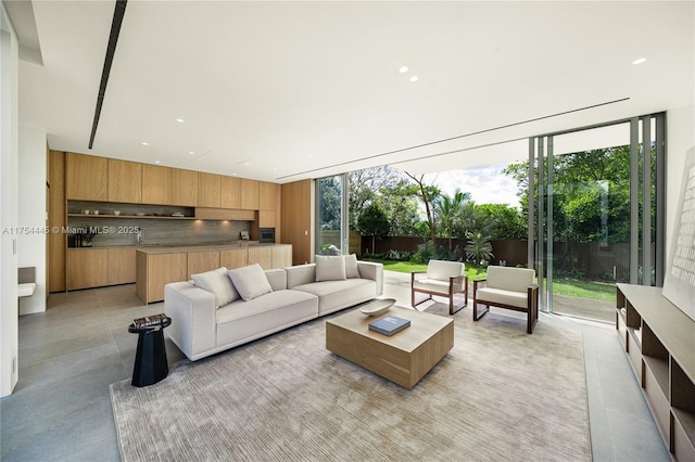 living area featuring recessed lighting, expansive windows, and concrete floors