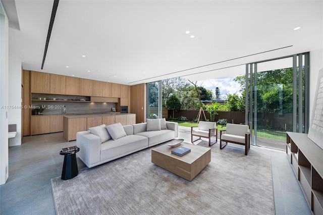 living area featuring recessed lighting, floor to ceiling windows, and concrete floors