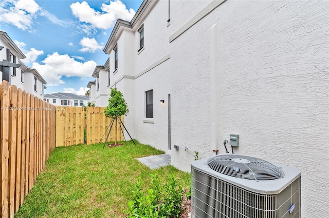 view of yard featuring fence and central AC unit