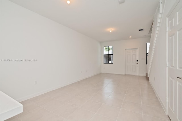 spare room with baseboards, visible vents, and light tile patterned flooring