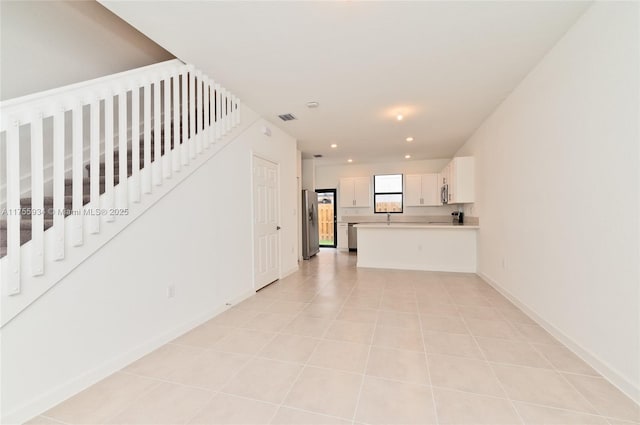 unfurnished living room with light tile patterned floors, visible vents, baseboards, stairs, and recessed lighting