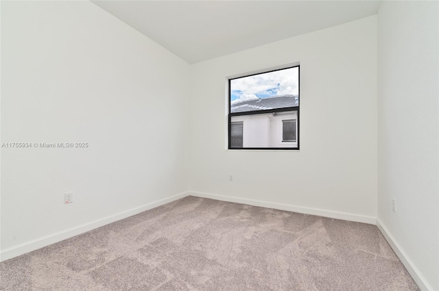 unfurnished room with carpet floors, lofted ceiling, and baseboards