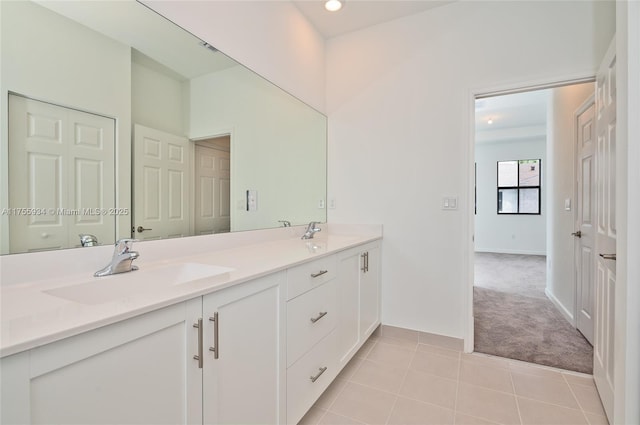 full bath featuring tile patterned flooring, a sink, baseboards, and double vanity