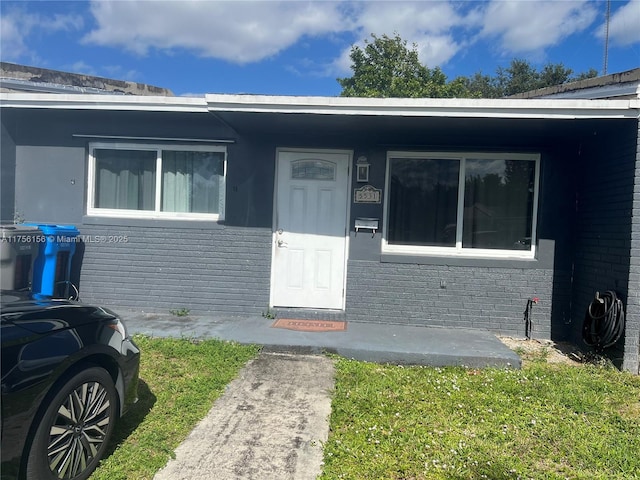 doorway to property with brick siding