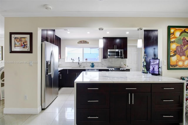 kitchen with light tile patterned floors, a sink, hanging light fixtures, appliances with stainless steel finishes, and tasteful backsplash