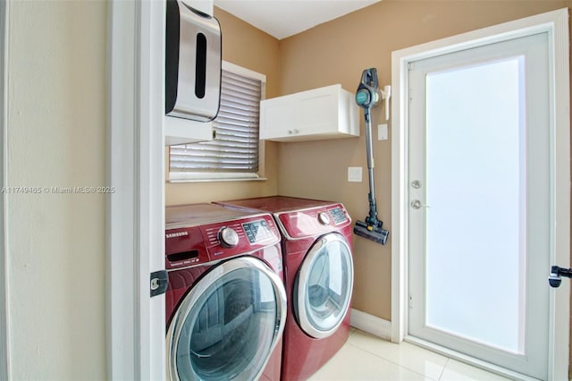 laundry area with light tile patterned floors, independent washer and dryer, and cabinet space