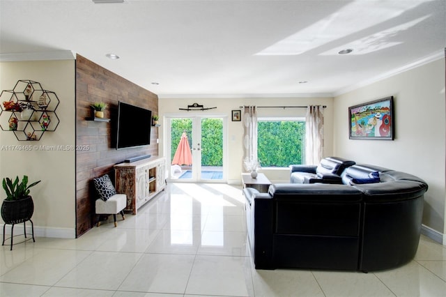 living room featuring ornamental molding, baseboards, and light tile patterned floors