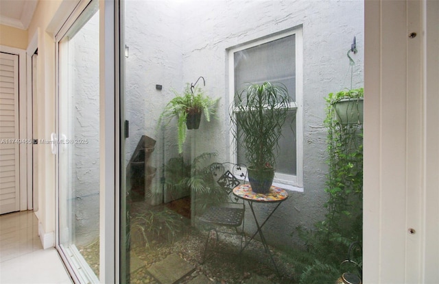 exterior space featuring tile patterned flooring and ornamental molding