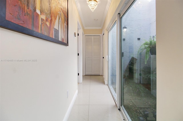 hall with ornamental molding, baseboards, and light tile patterned floors