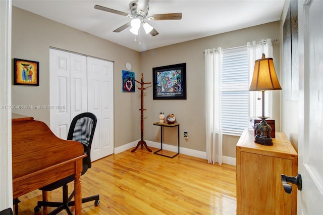 office space with light wood-style floors, baseboards, and a ceiling fan