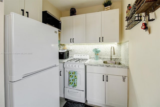 kitchen featuring white appliances, a sink, white cabinets, and decorative backsplash