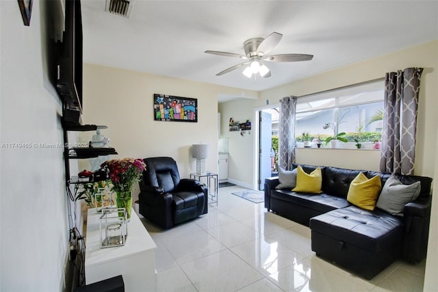 living area with ceiling fan, visible vents, baseboards, and light tile patterned flooring