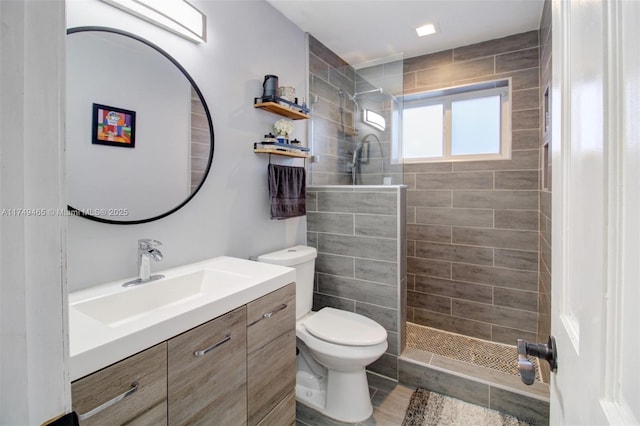 bathroom featuring toilet, walk in shower, and vanity