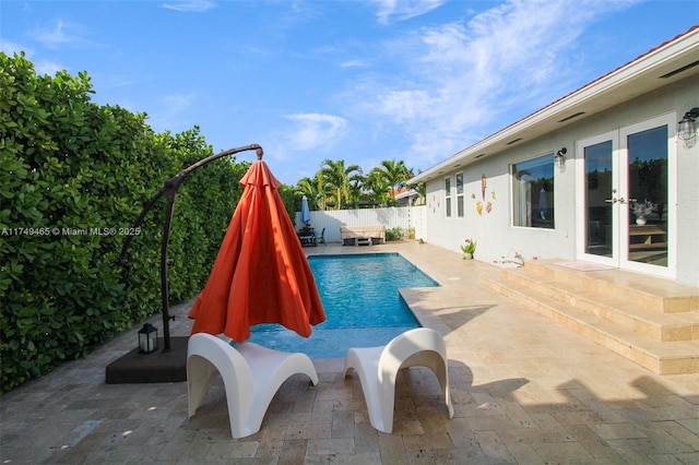 view of swimming pool with a fenced in pool, fence, a patio, and french doors