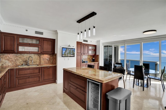 kitchen featuring beverage cooler, visible vents, a sink, light stone countertops, and backsplash