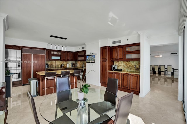 dining room featuring decorative columns, visible vents, and crown molding