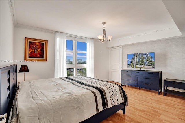 bedroom with a chandelier, baseboards, light wood-style flooring, and crown molding