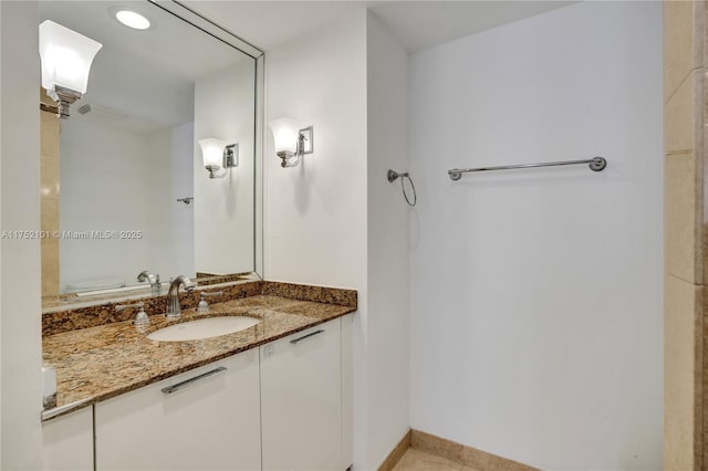 bathroom featuring toilet, vanity, and baseboards