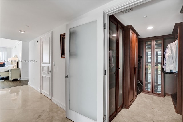 hallway featuring recessed lighting, visible vents, and baseboards