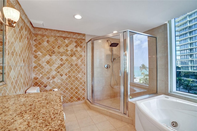 full bath featuring tile walls, recessed lighting, a stall shower, tile patterned flooring, and a whirlpool tub