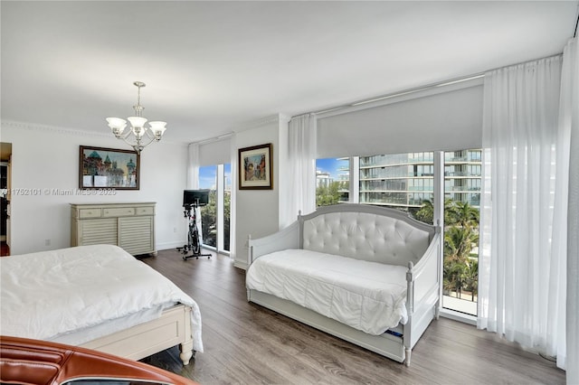 bedroom with wood finished floors and an inviting chandelier