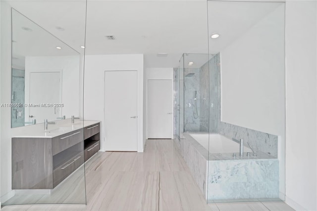 full bath with visible vents, vanity, a marble finish shower, and a bath