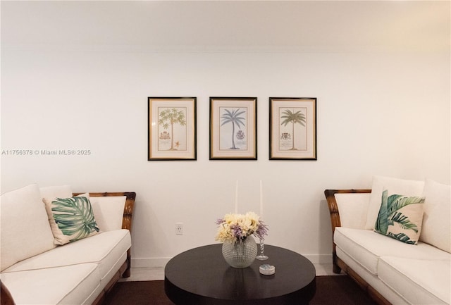 living area with baseboards and crown molding