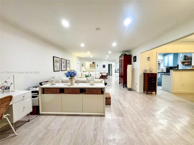 kitchen with recessed lighting, open floor plan, white cabinetry, light wood-type flooring, and a peninsula