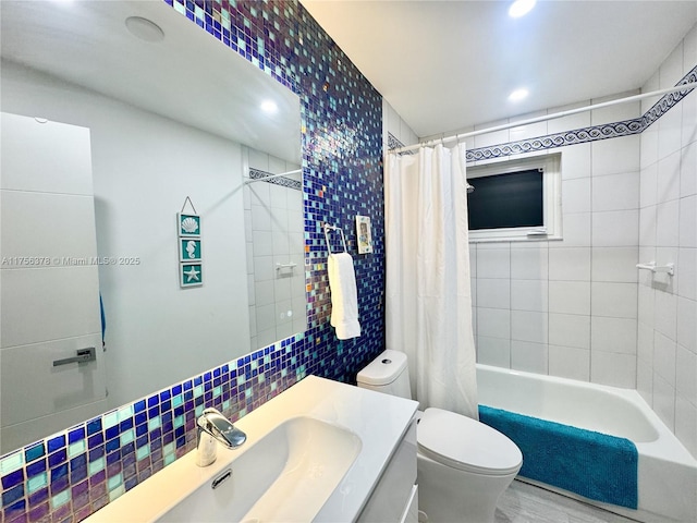 full bath with shower / tub combo, toilet, backsplash, vanity, and tile walls