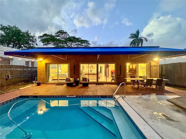 view of swimming pool featuring a patio area, fence, a fenced in pool, and outdoor dining space