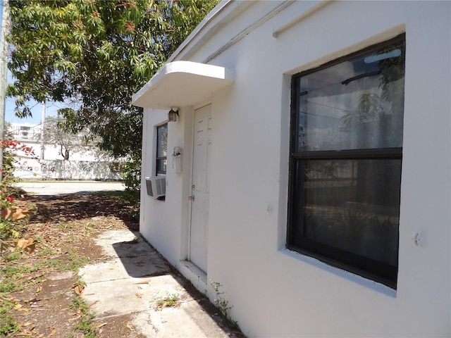 entrance to property with cooling unit and stucco siding