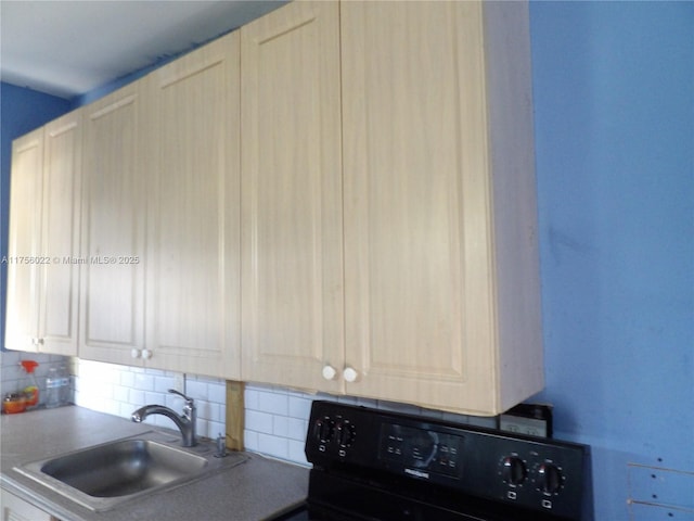 kitchen with white cabinets, black electric range oven, tasteful backsplash, and a sink