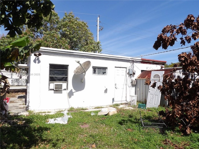 rear view of property with a yard, cooling unit, and an outdoor structure