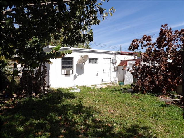 back of property with an outbuilding and a lawn