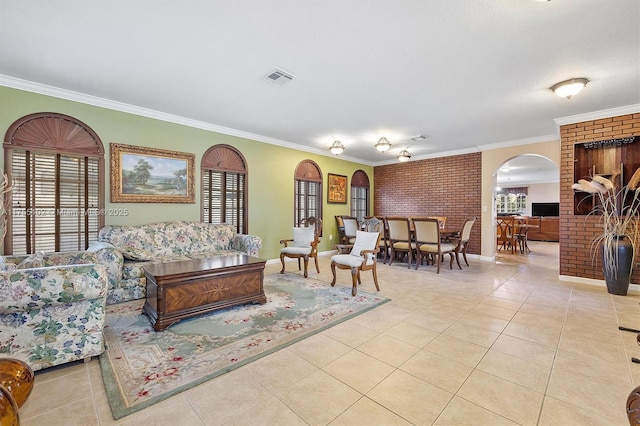 living area featuring a wealth of natural light, visible vents, ornamental molding, brick wall, and tile patterned flooring