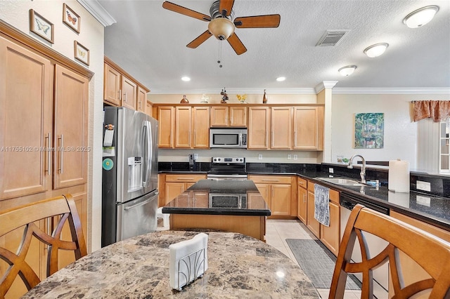 kitchen featuring appliances with stainless steel finishes, dark stone counters, visible vents, and a sink