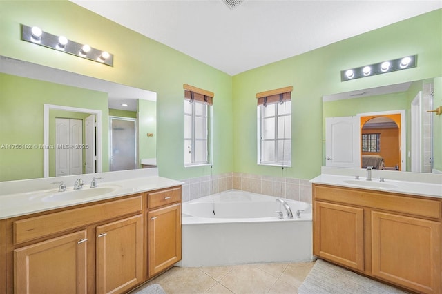 ensuite bathroom featuring ensuite bath, tile patterned flooring, a sink, and a shower stall