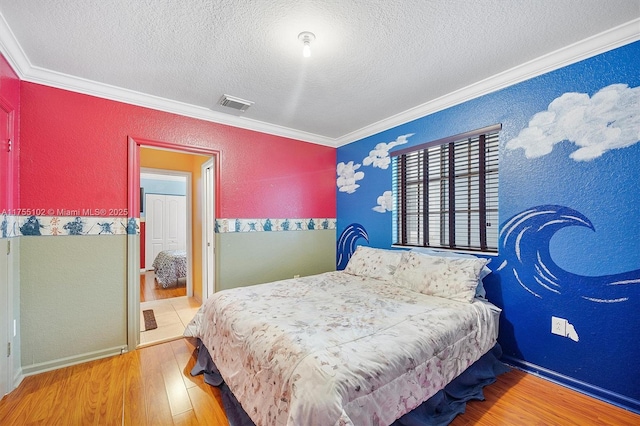 bedroom featuring a textured ceiling, a textured wall, wood finished floors, visible vents, and ornamental molding