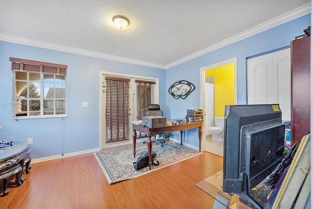 office space featuring ornamental molding, a textured ceiling, baseboards, and wood finished floors